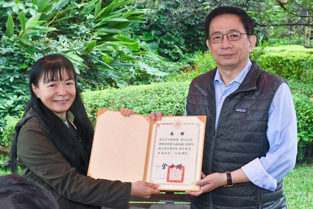 Image2:The National Taiwan University and the Taipei Zoo collaborated on the campus firefly restoration project. The President of the National Taiwan University presented a certificate of appreciation to the representative of the Taipei Zoo, thanking the Zoo for donating 1,200 Aquatica ficta firefly larvae for the release into the wild. Photographed together were the National Taiwan University President, Dr. Chung-Ming Kuan (to the right), and the Taipei Zoo Deputy Director Lucia Ju (to the left).
